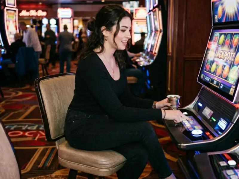 Woman playing slot machine at a casino, enjoying the gaming experience in a 55bmw slot casino environment